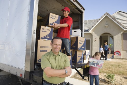 Movers transporting desks and boxes through a city office building