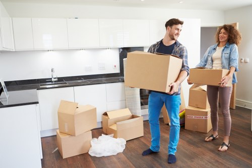 Professionals loading office furniture and IT equipment into a removals vehicle